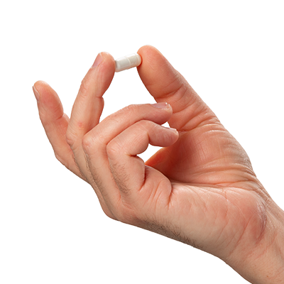 A single green leaf in a clear glass of water on white background.