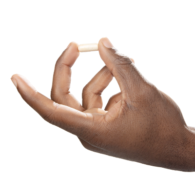 A single green leaf in a clear glass of water on white background.