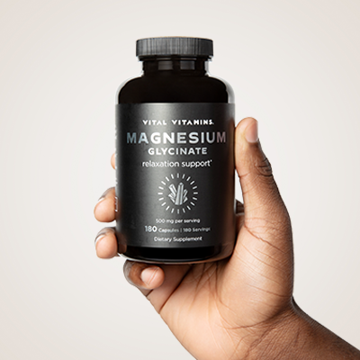 Green palm leaf beside two blank white cards on a white background.