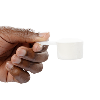 A single green leaf in a clear glass of water on white background.