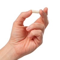 Hand holding a single white Probiotic Complex capsule on a clean background - Vital Vitamins 70 billion CFU probiotic supplement